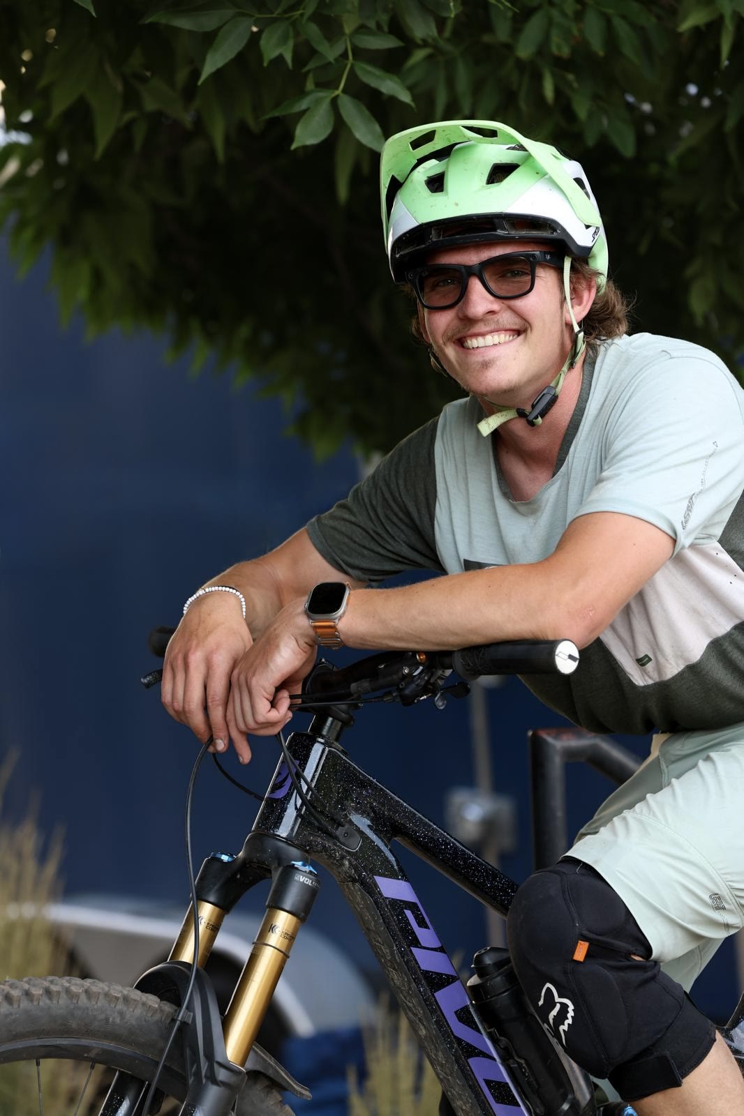 Cade Bergthold smiling beside a mountain bike